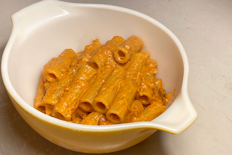 vodka sauce on pasta in a yellow vintage pyrex bowl
