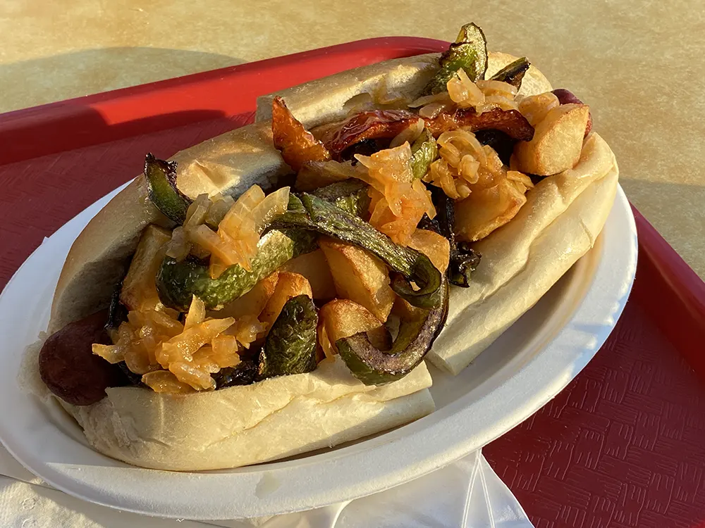 A single Italian hot dog from Johnny & Hanges in Fair Lawn topped with onions, peppers, and cubed potatoes