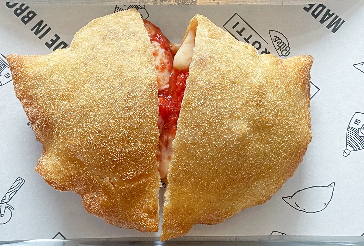 A panzerotto from panzerotti bites on Smith Street in Brooklyn, filled with mozzarella cheese and tomato sauce, fried in a thin pizza dough
